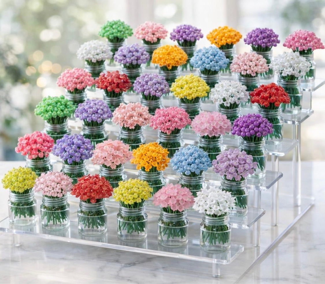 Beaded mini flower bouquets in glass jars on a display stand