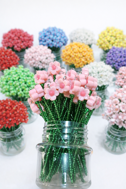 Beaded mini flower bouquets in pink and assorted colours, arranged in small glass jars